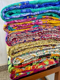 a pile of colorful fabric sitting on top of a wooden table