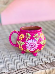 a pink vase sitting on top of a wicker table