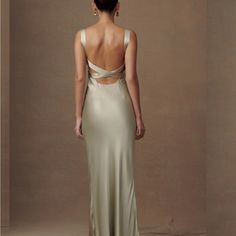 the back of a woman wearing a long dress with an open back and straps on it