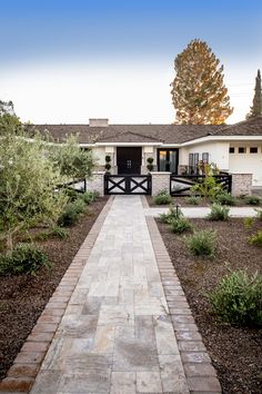 a white house with a brick walkway leading to the front door