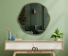 a mirror that is on the wall above a table with a potted plant in front of it