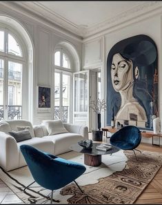 a living room filled with white furniture and large paintings on the wall above it's windows