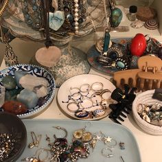 a table topped with lots of different types of jewelry and bracelets on top of plates