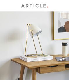 a wooden table with a lamp and books on it