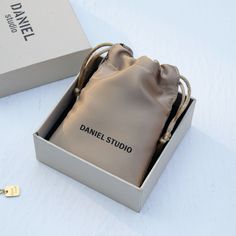 a small bag sitting inside of a box on top of a white table next to a key