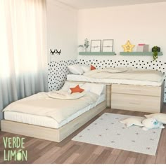 two beds in a room with polka dot wallpaper and wooden flooring on the walls