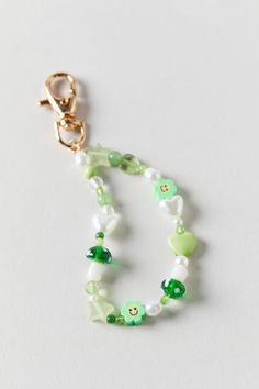 a green and white beaded necklace on a gold plated clasp with an animal charm