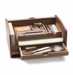 a wooden desk drawer filled with office supplies