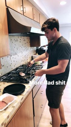 a man standing in front of a stove top oven with food on the burners