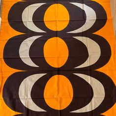 an orange, black and white banner with circles on it's sides is laying on the floor