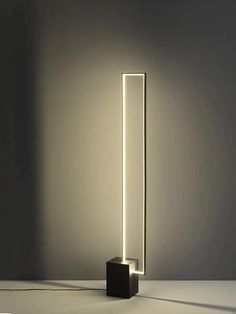 an illuminated floor lamp in the shape of a rectangle, on a white surface