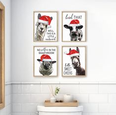 three farm animals wearing christmas hats on the wall above a toilet in a white bathroom