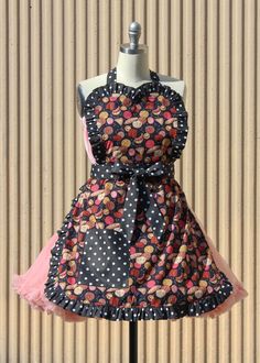 a dress on a mannequin with polka dots and pink ribbon around the waist