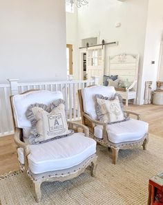 two chairs and a chair with pillows on them in front of a white crib