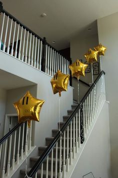 some gold stars are hanging on the stairs