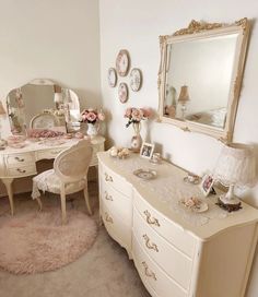 a white dresser sitting next to a mirror on top of a wooden table covered in pink flowers