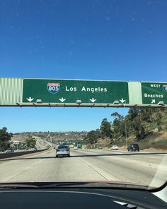 a highway sign that says los angeles and the freeway below it is green with white arrows