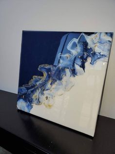 a blue and white abstract painting on a black table