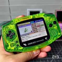 a person holding a game boy advance in their hand