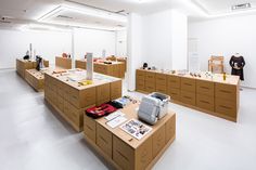 an empty room filled with lots of wooden boxes and items on top of tables in front of two mannequins