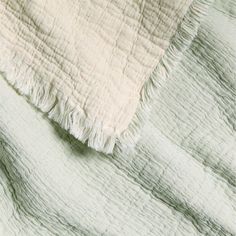 a white blanket with fringes on top of it