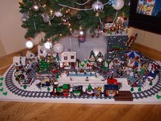 a christmas tree is next to a lego train set