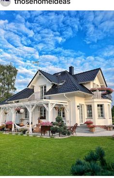 a large white house sitting on top of a lush green field