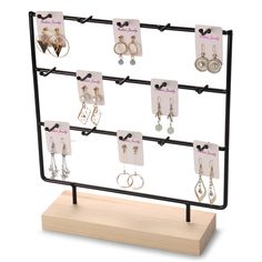 a display case with earrings and earring hooks on it's sides, holding several pairs of earrings