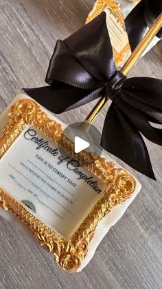 a gold frame with a black bow is on the table next to an award ribbon