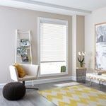 a living room filled with furniture and two large windows covered in shades of white blinds