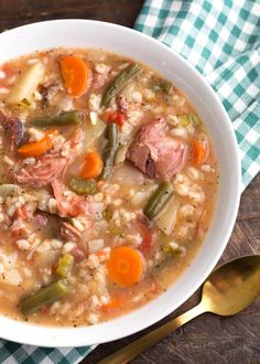 a white bowl filled with meat and vegetable soup