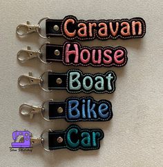 four keychains with the words caravan house boat bike car on each one side