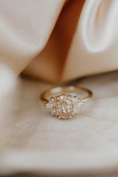 an engagement ring sitting on top of a white cloth