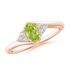 The twisted shank ring features an oval peridot in a prong setting, complemented by a trio of round diamonds on the sides. With the curvy bypass design of the band, this golden-green peridot ring exudes a playfully feminine look. It is crafted in 14k rose gold. Peridot Rings, Golden Green, Bypass Ring, Peridot Ring, Green Peridot, Feminine Look, 18k Rose Gold, Prong Setting, Round Diamonds