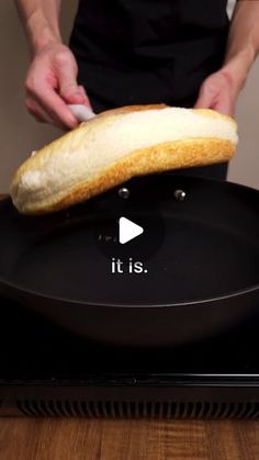 a person holding a piece of bread on top of a frying pan