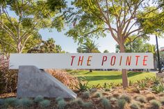 the sign for the pointe is in front of some trees and grass with bushes