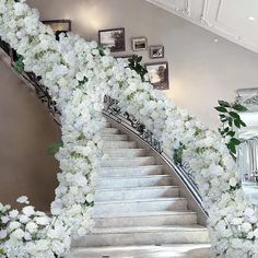 a staircase with white flowers and greenery on it