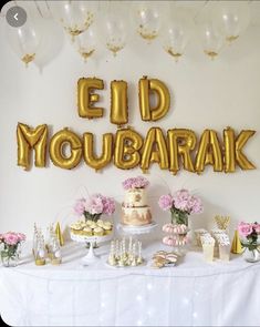 a table topped with lots of desserts and balloons that say eld moubarak