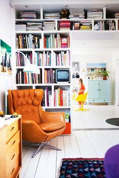 a living room filled with furniture and bookshelves covered in lots of bookcases