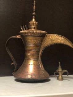 an antique brass coffee pot on display in a museum