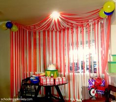 a room with red and white striped curtains on the wall, balloons in the air