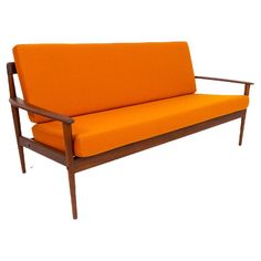 an orange couch sitting on top of a wooden frame