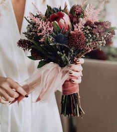 a woman holding a bouquet of flowers in her hands