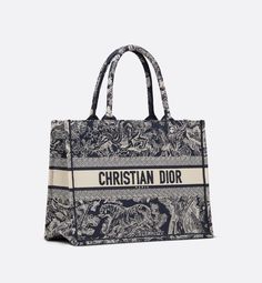 Introduced by Maria Grazia Chiuri, Creative Director of Christian Dior, the Dior Book Tote has become a staple of the Dior aesthetic. Designed to hold all the daily essentials, the style is fully embroidered with the blue and ecru Toile de Jouy Reverse motif, a variation of the House's hallmark pattern with a play on reversed colors. Adorned with the Christian Dior Paris signature on the front, the medium tote exemplifies the House's signature savoir-faire and may be carried by hand or worn over Christian Dior Tote Bag, Christian Dior Tote, Dior Tote Bag, Black Toile, Dior Aesthetic, Plan Paris, Dior Book, Christian Dior Paris, Dior Paris