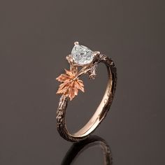 "A hand made twig and leaf ring set with a pear shaped diamond. The ring displays a beautiful twig pattern along with a maple leaf that creates a pleasantly asymmetrical result. A delicate, handmade engagement ring made in two gold colors and set with a natural white diamond of high quality. The grooves in the band are plated with black rhodium which emphasizes the texture. if you prefer not to apply the black rhodium that is fine. I can also use white, rose or yellow gold for the band and the l Twig Engagement Ring Vintage, Maple Leaf Engagement Ring, Laurel Leaf Engagement Ring, Leaf Wedding Ring Pair, Engagement Ring Twig Band, Leaf Engagement Ring Simple, Twig And Leaf Engagement Ring, Unique Engagement Rings Leaf Band, Juniper Leaf Ring