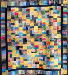 a colorful quilt is hanging on the wall