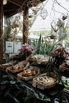 an assortment of pastries and desserts on display in a garden setting with greenery