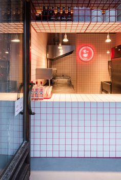 the interior of a restaurant with red and white tiles on the walls, along with lights hanging from the ceiling