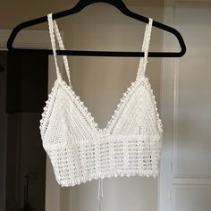 a white bra hanging on a black hanger