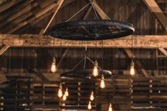 several light bulbs hanging from the ceiling in a barn